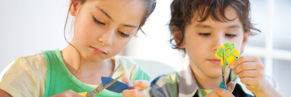 Child practicing scissor skills with paper during an occupational therapy activity